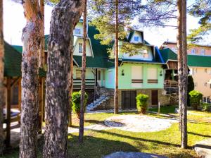 a house with a green roof and trees at BonaMi Divcibare in Divčibare