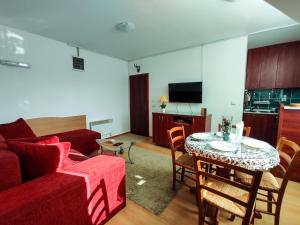 a living room with a couch and a table with chairs at BonaMi Divcibare in Divčibare