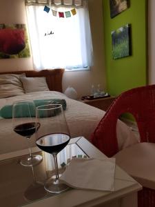 a room with a bed and two glasses of wine on a table at THE POPPIES Joy of Living by The Ocean! in Candelaria