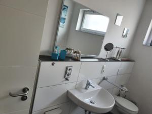 a white bathroom with a sink and a mirror at Mehr Meer geht nicht 2.0 in Wilhelmshaven