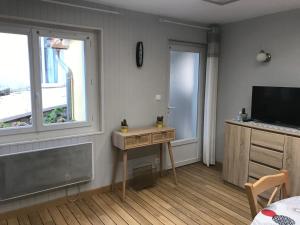a room with a desk and a television and a bed at Petite maison proche du centre ville in Cauterets