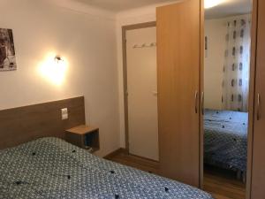 - une petite chambre avec 2 lits et un placard dans l'établissement Petite maison proche du centre ville, à Cauterets