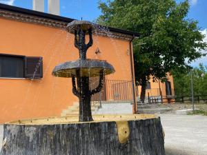 una fontana d'acqua seduta sopra un tronco d'albero di BORGO DON ARMANDO - Appartamento A B C E a Francavilla in Sinni