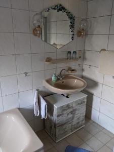 a bathroom with a sink and a mirror and a toilet at Ferienwohnung Lücking im Westerwald in Flammersfeld +20 photos
