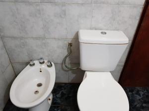 y baño con aseo blanco y lavamanos. en Casa Amarrilla en San Clemente del Tuyú
