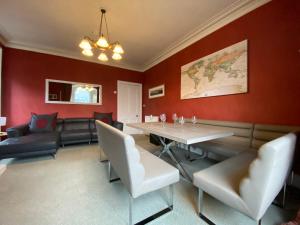 una sala da pranzo con pareti rosse e tavolo e sedie di Period House / Entire Upstairs Flat a Inverness