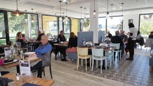 a group of people sitting at tables in a restaurant at The Originals Access, Hôtel Millau Sud in LʼHospitalet-du-Larzac +35 photos