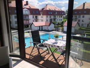 a table and a chair on a balcony with a pool at Middelkerke green garden in Middelkerke