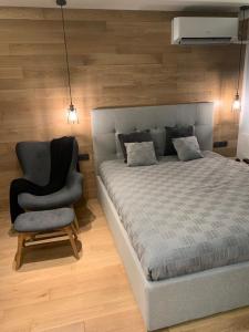 um quarto com uma cama e uma cadeira em LUXURIOUS ONE BEDROOM STUDIO IN TOP CENTER em Blagoevgrad