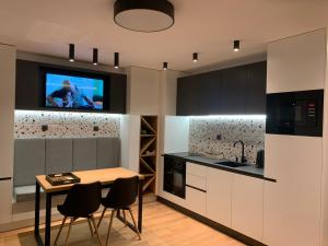 a kitchen with a table and a tv on a wall at LUXURIOUS ONE BEDROOM STUDIO IN TOP CENTER in Blagoevgrad