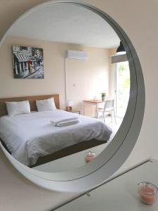 a bedroom with a white bed and a round mirror at Pissouri Image in Pissouri