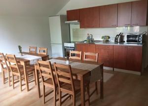 una cucina con tavolo e sedie in legno e una cucina con cucina di Penzion Lea v Patinciach a Patince