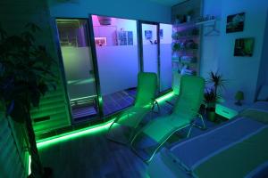 um quarto com cadeiras verdes num quarto com luzes em Wellnessapartment em Oberhausen