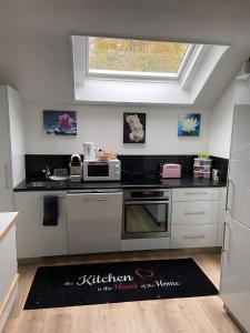 a kitchen with a black counter top with a microwave at Casa Wellbella in Unterkulm