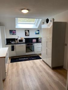 a kitchen with white appliances and a large window at Casa Wellbella in Unterkulm