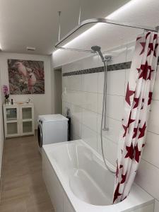 Casa Wellbella في Unterkulm: حمام أبيض مع حوض استحمام ودش