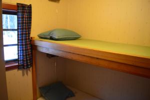 Etagenbett in einem kleinen Zimmer mit Fenster in der Unterkunft Stuga i Pålles Stugby in Duved