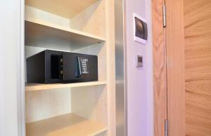 a microwave sitting on a shelf in a closet at Hotel Jucamar in Cangas de Morrazo