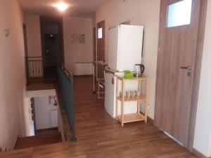 a kitchen with a white refrigerator and a staircase at Noclegi Pod Dębem in Skawina