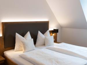 uma grande cama branca com almofadas brancas em Hotel Gasthof Rosenwirt em Au in der Hallertau
