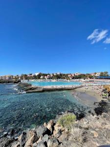una spiaggia con un gruppo di persone in acqua di Oasis Costa del Silencio a Costa Del Silencio