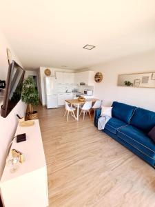 a living room with a blue couch and a table at Sea View in Playa del Aguila