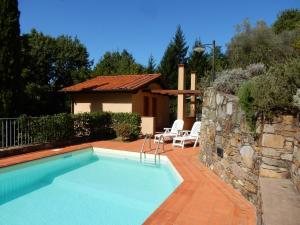 a swimming pool in a yard with a house at Oliveto Cottage in Capannori