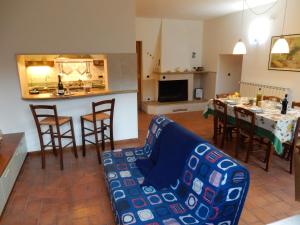 a living room with a couch and a kitchen with a table at Oliveto Cottage in Capannori