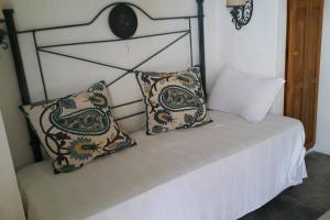 Una cama blanca con dos almohadas encima. en Alquiler Habitación Independiente en el centro de José Ignacio!, en José Ignacio