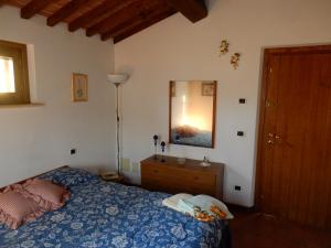 a bedroom with a bed and a dresser and a mirror at Oliveto Cottage in Capannori +28 photos