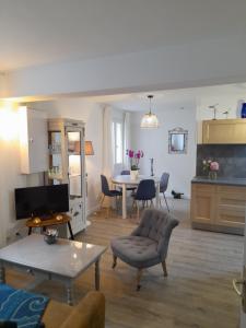 a living room with a table and a dining room at La Cour Royale in Bayeux