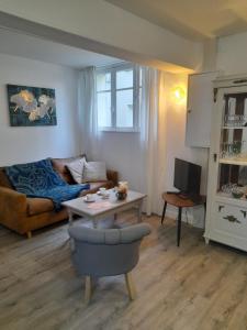 ein Wohnzimmer mit einem Sofa und einem Tisch in der Unterkunft La Cour Royale in Bayeux