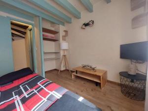 - une chambre avec un lit et une télévision à écran plat dans l'établissement Petite maison de vacances en Cévennes, à Florac Trois Riviere