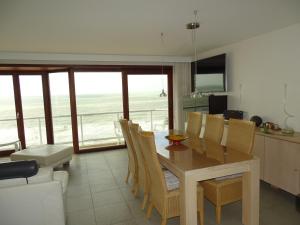 a kitchen and dining room with a table and chairs at LUXURY APP, frontal sea View + south terrace + garage in Middelkerke