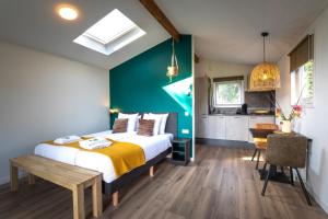a bedroom with a bed and a table and a bathroom at Grenzeloos in Doldersum