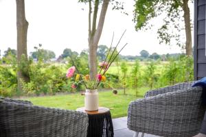 a vase with flowers on a table on a patio at Grenzeloos in Doldersum +10 photos