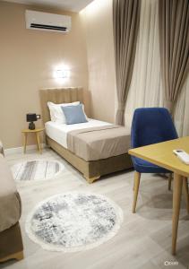 1 dormitorio con 1 cama, 1 mesa y 1 silla azul en Vila Livi en Korçë