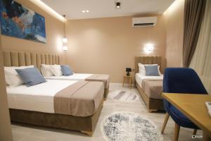 ein Hotelzimmer mit 2 Betten und einem Schreibtisch in der Unterkunft Vila Livi in Korçë
