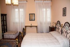 ein Schlafzimmer mit einem Bett und zwei Fenstern in der Unterkunft Appartamento Porta Crucifera in Arezzo