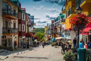 a street in a town with people walking down the street at Unique Tremblant view -fancy fully equipped apartment in Mont-Tremblant