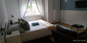 ein kleines Schlafzimmer mit einem Bett und einem Fenster in der Unterkunft Apartman 3 in Komárom