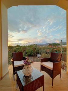 eine Terrasse mit 2 Stühlen und einem Tisch mit einer Vase darauf in der Unterkunft B&B Villa Sara Falconara in Licata