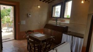 - une cuisine avec une table et des chaises dans la chambre dans l'établissement MYRTUS PODERE CUNINA, à Buonconvento