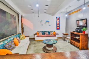 a living room with a couch and a table at La Gloria House in Ilhabela