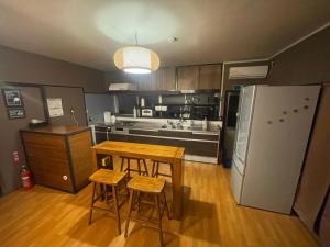 a kitchen with a table and chairs and a refrigerator at tsukigakireidesune in Kumamoto