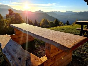 una panchina di legno in cima a una montagna di Chalet Chapeau b&b a Castel Condino