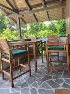 einen Holztisch und zwei Stühle auf einer Terrasse in der Unterkunft Beautiful Chalet with view to the lake in Pihovec