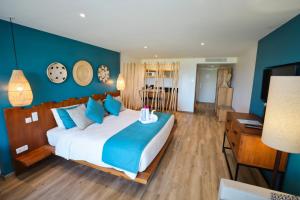 a bedroom with a large bed with blue walls at Orient Beach Hotel in Orient Bay