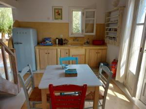 a kitchen with a table and chairs and a refrigerator at Simos suites in Elafonisos