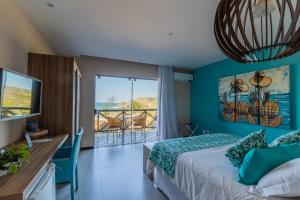 a bedroom with a bed and a view of the ocean at Hotel Pousada Brava Club in Búzios